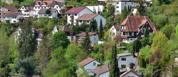 Cute village in Germany on a hillside, apartment buildings on the background of the forest