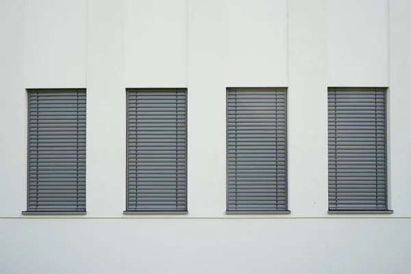 Cztery Wąskie Okna Zamkniętymi Szarymi Okiennicami Ścianie — Zdjęcie stockowe