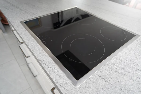 Induction cooker with a black glass surface in the kitchen