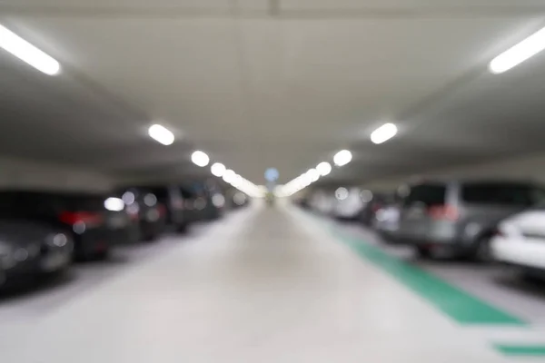 Aparcamiento subterráneo de fondo borroso para coches en el centro comercial. Imagen condenada — Foto de Stock