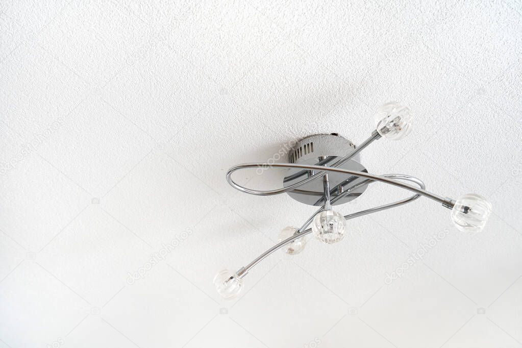 Small curved chandelier against the white ceiling