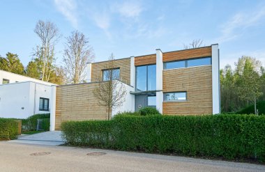 Pforzheim, Almanya - 21 Nisan 2019: Ahşap duvarı ve büyük bir garajı olan modern bir evin cephesi