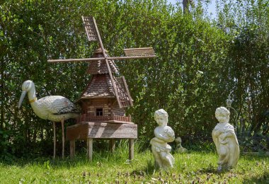 Pforzheim, Almanya - 18 Nisan 2019: bahçedeki dekorlar için rakamlar. Küçük değirmen, balıkçıl ve insan figürleri.