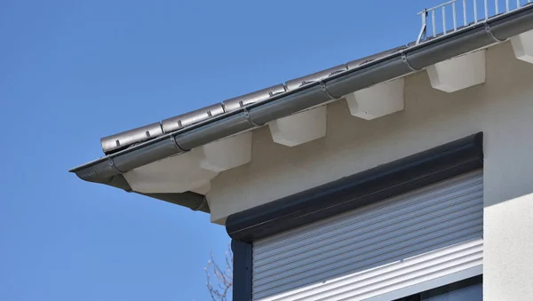 System odwadniający na dachu domu. rynna deszczowa z dachu na tle błękitnego nieba z miejscem na tekst — Zdjęcie stockowe