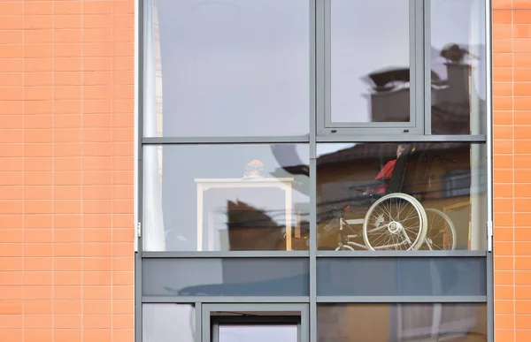 Pforzheim, Alemania - 23 de abril de 2019: La ventana de la casa para las personas mayores en la que se puede ver al anciano en una silla de ruedas. Casa de ancianos en una ciudad europea — Foto de Stock