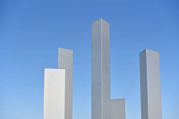 Abstrakte Metallsäulen auf blauem Himmelshintergrund mit Textfläche — Stockfoto