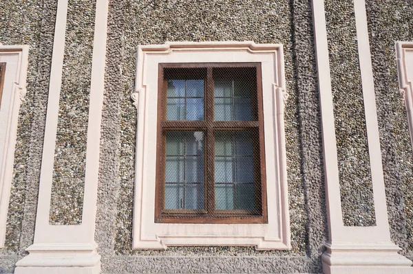 Окно старого здания, накрытого специальной сеткой от повреждений в европейском городе — стоковое фото