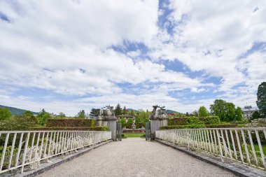 Avrupa şehri Baden Baden 'de halka açık bir parkın girişindeki güzel beyaz demir köprü. Yeşil parka bakan bir köprüye sahip manzara
