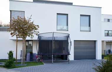 Pforzheim, Almanya - 21 Nisan 2019: Hudora trambolin atlama modern bir evin ön avlusunda duruyor
