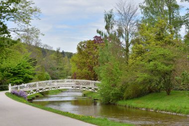 Avrupa 'nın Baden şehrinde nehrin üzerinde dövülmüş güzel bir demir köprü. Nehir üzerinde bir köprüsü olan manzara