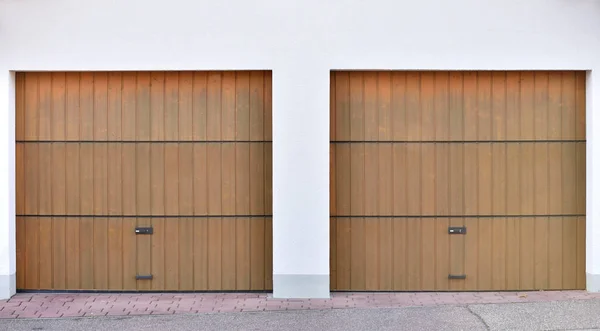 Two brown garage doors in a European city. Garages for two cars
