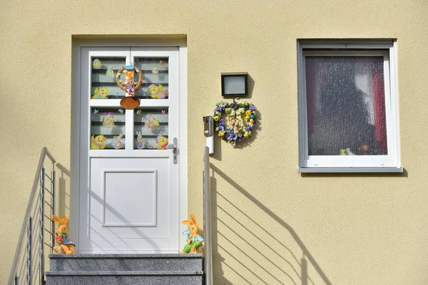 Pforzheim, Alemania - 22 de abril de 2019: Puerta blanca de entrada a la casa, decorada para Semana Santa con vigas y liebres.. — Foto de Stock