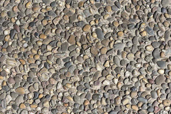 Pebble stones wall texture. Finishing the foundation of the house with pebbles. Template