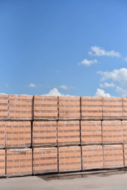Yeni tuğlalar mavi gökyüzüne karşı fabrikanın açık hava deposunda duruyor..