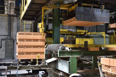 Yığılan tuğlalar sonraki paketleme için satır boyunca seyahat ederler.