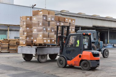 Stariy Oskol, Rusya - 5 Kasım 2019: traktörün getirdiği kutuları küçük bir forklift boşalttı