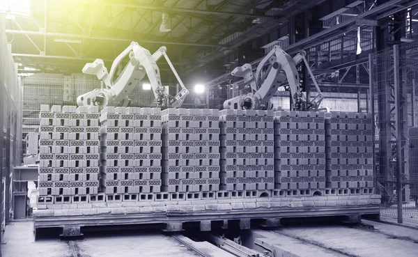 Robots manipulators stack bricks in a brick factory