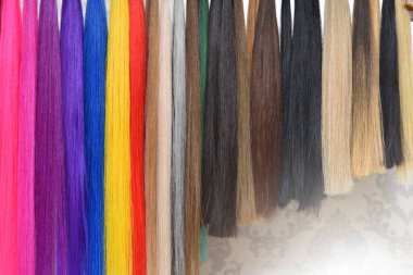 Uzatmak için farklı renkte saçlar bir güzellik salonunda askıda asılı duruyor..