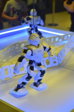 Küçük oyuncak robot dans ediyor ve bir robot sergisinde hareket ediyor. Robot Şehri