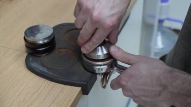 Barista kahve yapar ve elinde bir iskele filtresi tutar ve kahve yapar..
