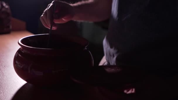 Muž kuchař míchá lžíci s horkým sirupem topping, viditelné horké páry — Stock video