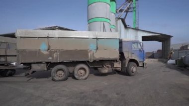 Kirli bir kargo kamyonu güneşli bir günde fabrikadan geçiyor..