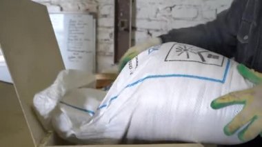 Stariy Oskol, Rusya - 4 Mart 2020: Bir erkek işçi hayvan yemi üretimi sırasında poşetten bir katkı maddesi ekler