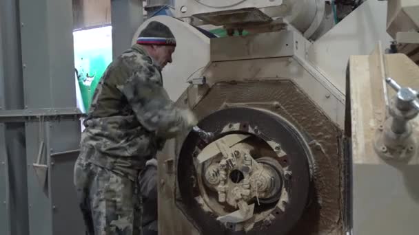 Stariy Oskol, Rusia - 4 de marzo de 2020: Un hombre adulto está reparando equipos en una fábrica de piensos . — Vídeos de Stock