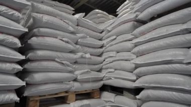 Kırsal hayvanlar için katlanmış beyaz yem torbalarıyla üretim deposu. Tarım ve Kaynak Kavramı