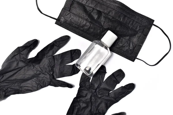 Luvas de proteção pretas, máscara protetora preta e gel anti-séptico sobre um fundo branco. Conceito de higiene e proteção contra coronavírus — Fotografia de Stock