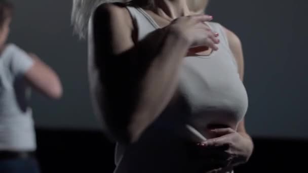 Sexy female dancer breasts while dancing on a dark stage. Close-up — Stock Video