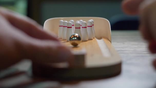 Mini bowling, bordspel, een ijzeren bal rolt en slaat alle pinnen, het concept van het winnen en raken van het doel — Stockvideo