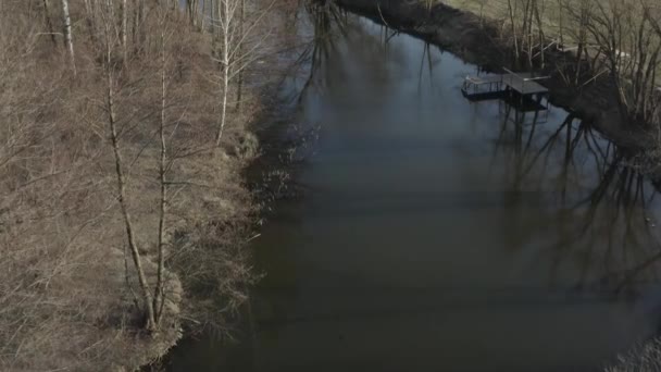 Vuelo de drones sobre el río con una vista de árboles de primavera sin hojas . — Vídeos de Stock