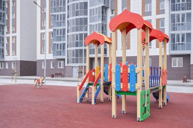Yeni bir apartmanın arka planında, çocuklar için yeni bir oyun alanı