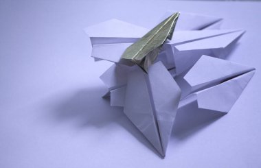 Gold and white origami paper airplanes on a white background