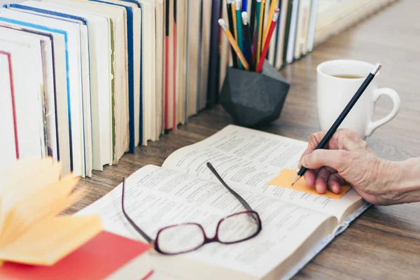 Pila de libros educación fondo, mano femenina hace notas nea — Foto de Stock