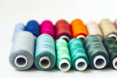 Kopya alanı olan renkli dikiş ipliği bobinleri beyaz arkaplanda 