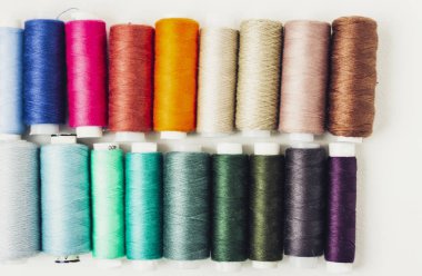 Kopya alanı olan renkli dikiş ipliği bobinleri beyaz arkaplanda 