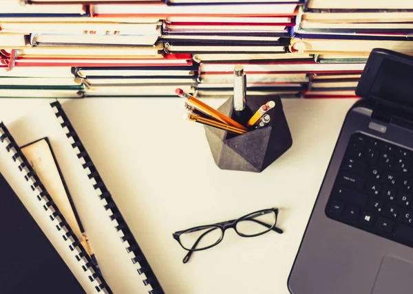 Pila de libros, cuaderno, portátil, gafas en el fondo de la oficina f — Foto de Stock