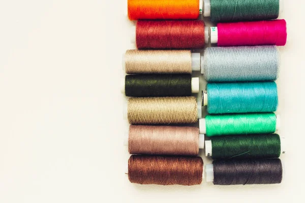 Kolorowe cewki nici do szycia na białym tle z przestrzenią do kopiowania — Zdjęcie stockowe