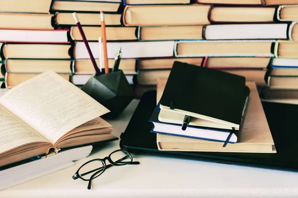 Pila de libros, cuaderno, portátil, gafas en el fondo de la oficina f — Foto de Stock