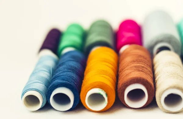 Bobine di filo da cucire colorate su sfondo bianco con spazio di copia — Foto Stock