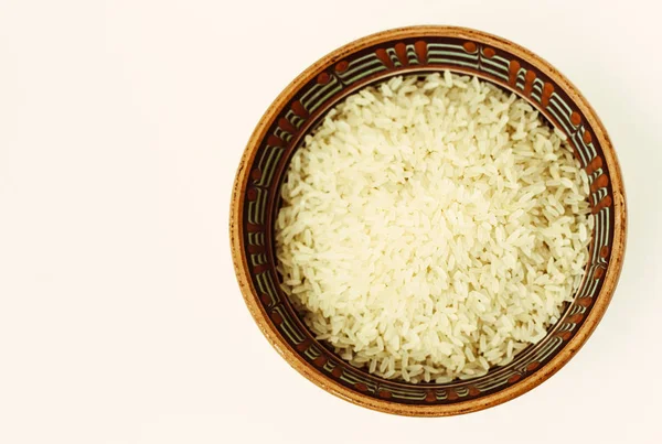 Ceramic brown bowl with long rice on white background top view. — Stock Photo, Image