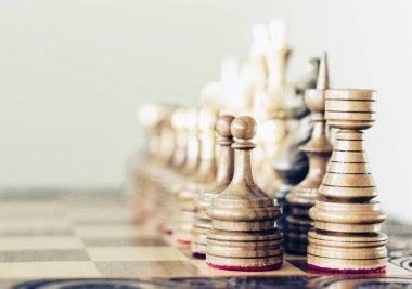 Satranç tahtasında tahta satranç taşları, beyaz üzerinde liderlik kavramı.