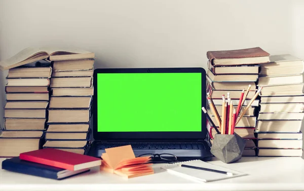 Ordenador portátil de pantalla verde, pila de libros, cuadernos y lápices en wh — Foto de Stock