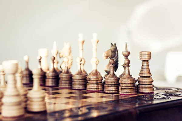 Wooden chess pieces on a chessboard, leadership concept on white