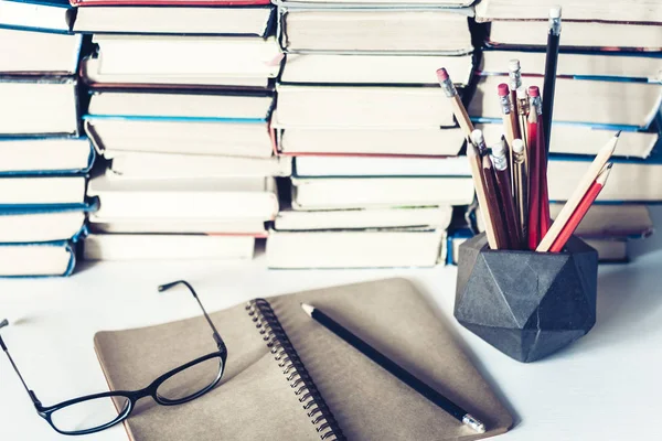 Jegyzetfüzet, ceruza, szemüveg és köteg könyv, iskolai háttér — Stock Fotó