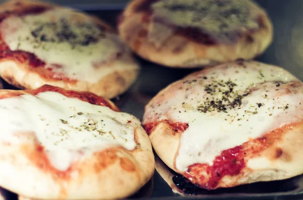 Mini pizza with ham, mozzarella, tomato sauce from the oven in b