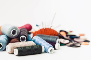 Dikiş için kırmızı örülmüş iğne yastığı ve renkli iplik bobinleri