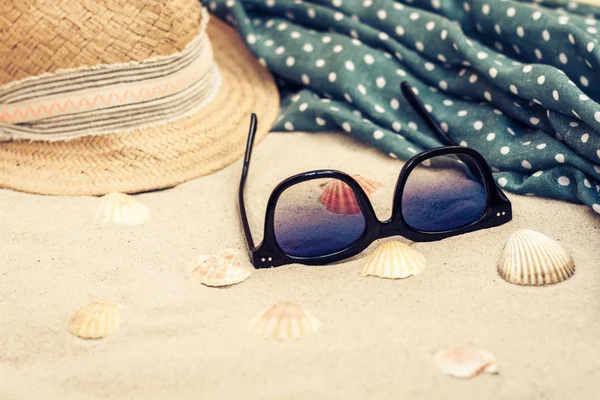 Straw hat, cover-up beachwear wrap and sun glasses on a tropical